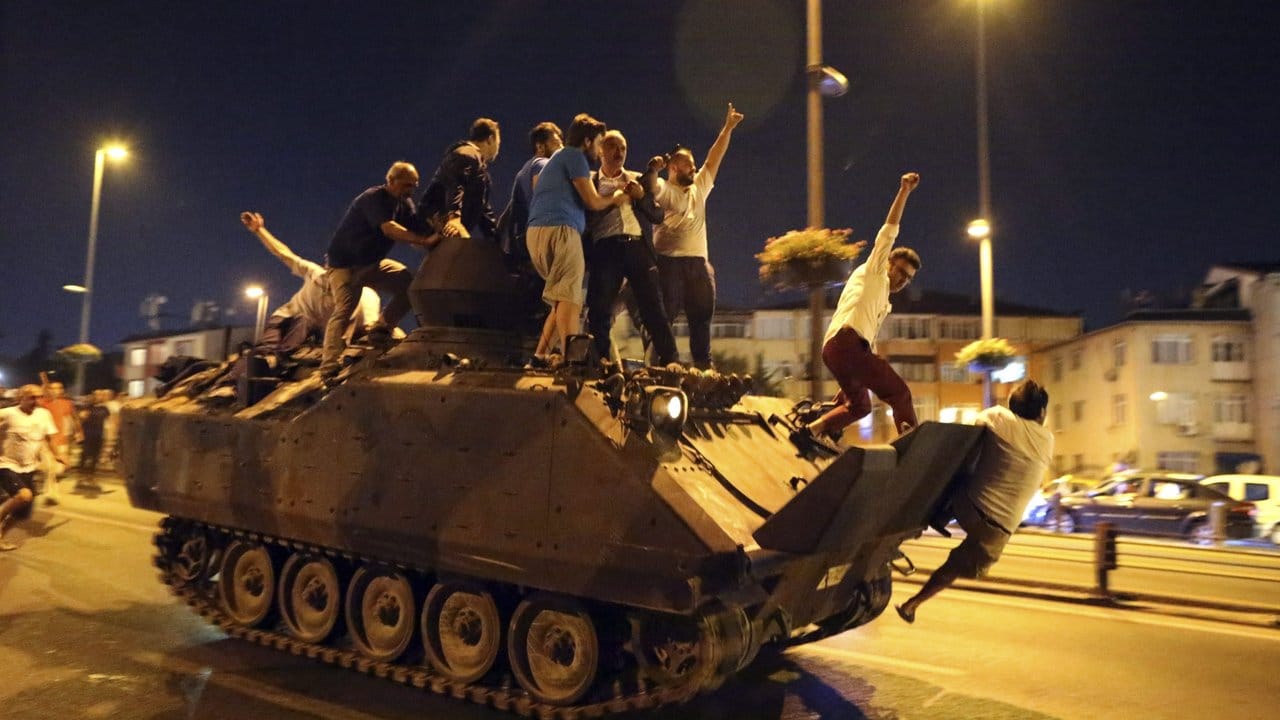 Menschen besetzen einen Transportpanzer der Türkischen Armee.
