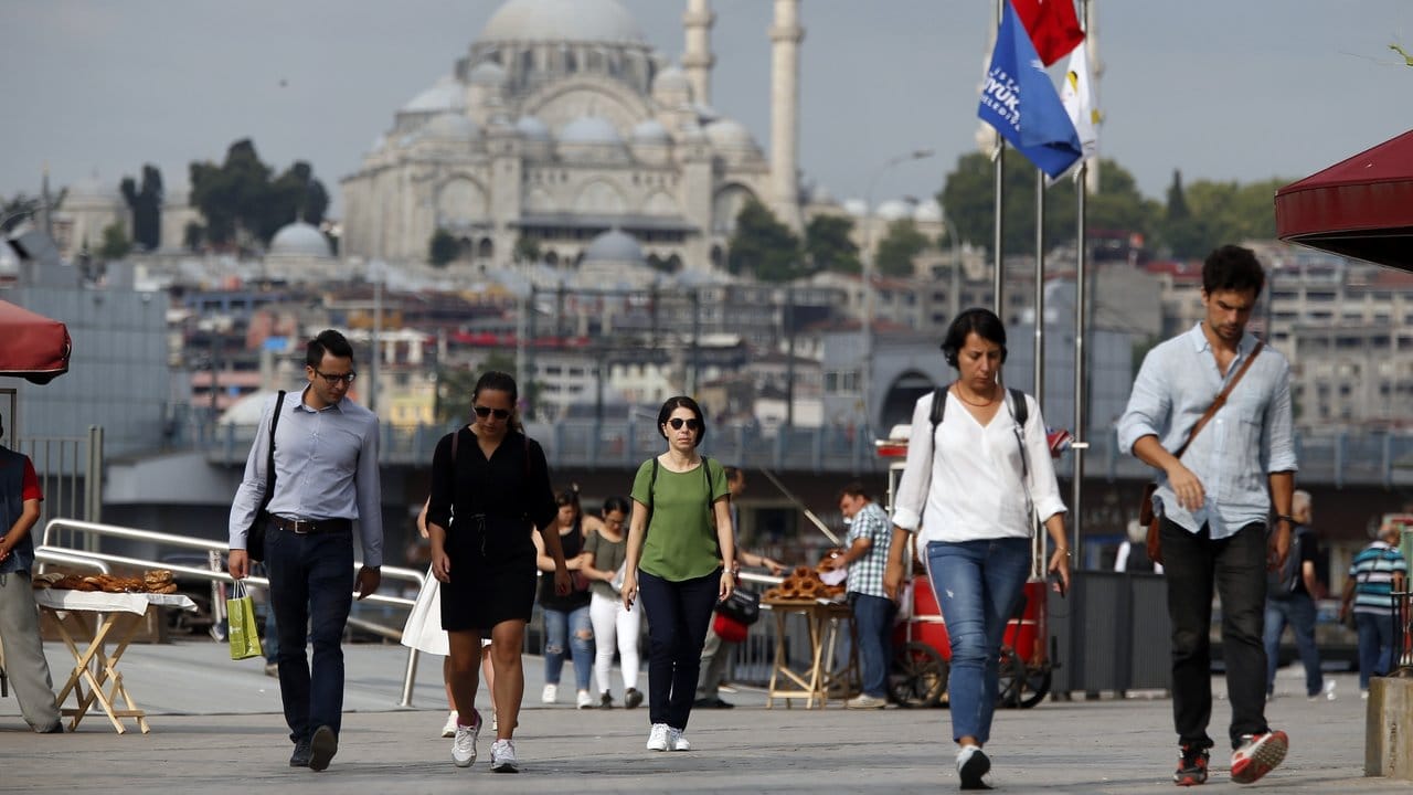 Fußgänger laufen in Istanbul eine Straße entlang.