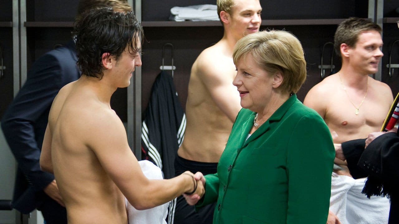 Bundeskanzlerin Angela Merkel gratuliert Mesut Özil nach dem EM-Qualifikationsspiel gegen die Türkei in der Mannschaftskabine des Berliner Olympiastadions.