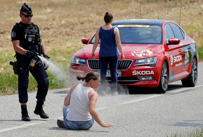 Eine Frau weigert sich die Straße zu verlassen und wird vom Polizisten aus nächster Nähe mit Pfefferspray attackiert.