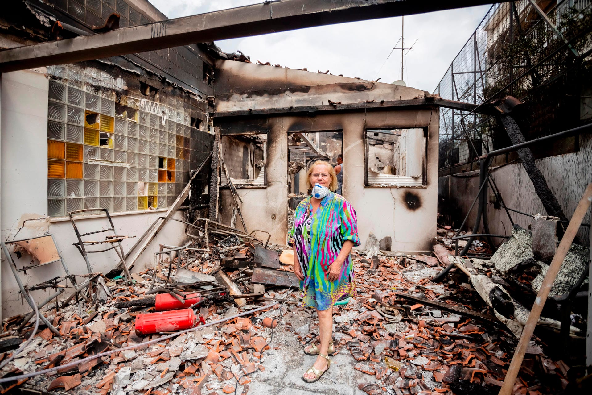 Einige konnten ihre Häuser nicht vor den Flammen retten. Eine Frau steht in ihrem zerstörten Haus in Mati.