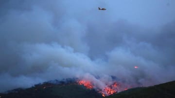 Ein Flugzeug fliegt über einem Waldbrand in Mati. Zwei große Waldbrände westlich und östlich von Athen sind am vergangenen Montag außer Kontrolle geraten.