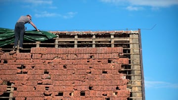 Ein Unwetter kann an einem Hausdach schwere Schäden anrichten.