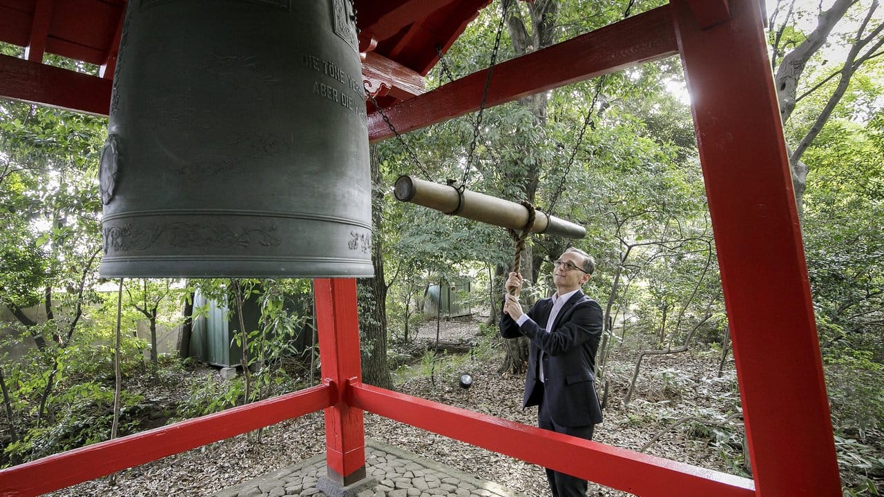 Außenminister Maas schlägt im Garten der Residenz der Deutschen Botschaft in Tokio die Glocke der japanisch-deutschen Freundschaft.