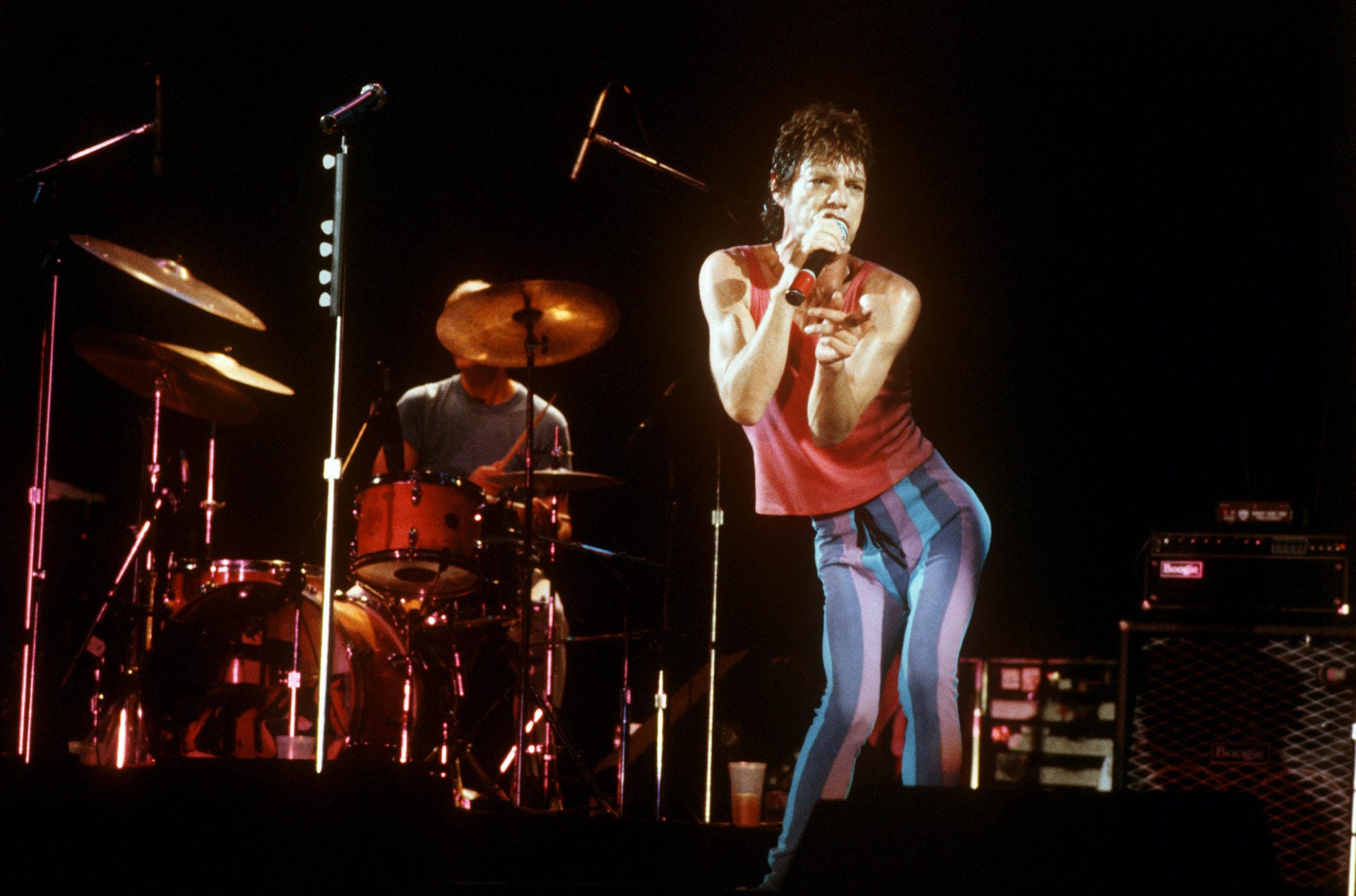1982: Der Frontman der britischen Rockgruppe inszeniert sich in extravaganter Bühnenkleidung.