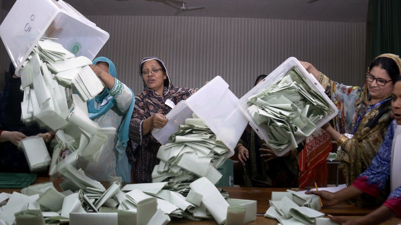 Helferinnen leeren Wahlurnen in einem Wahllokal in Islamabad. Helferinnen leeren Wahlurnen in einem Wahllokal in Islamabad.