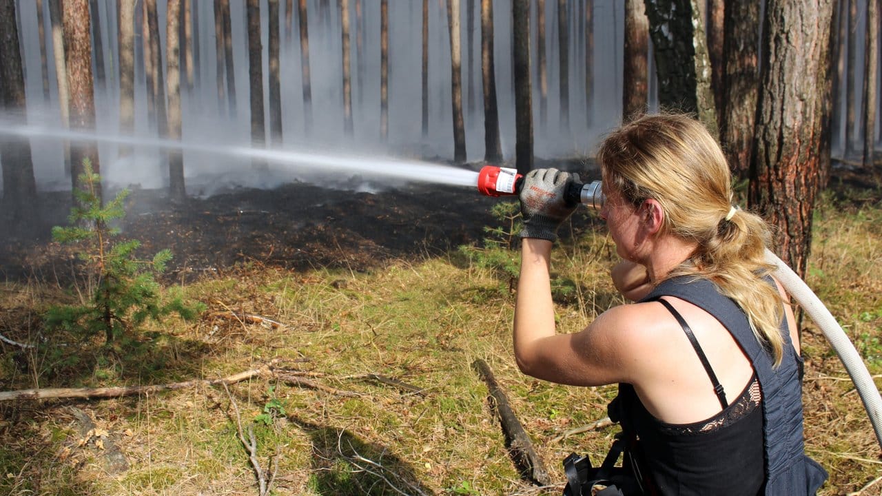 Eine Feuerwehrfrau beim Löscheinsatz gegen den Waldbrand. Eine Feuerwehrfrau beim Löscheinsatz gegen den Waldbrand.