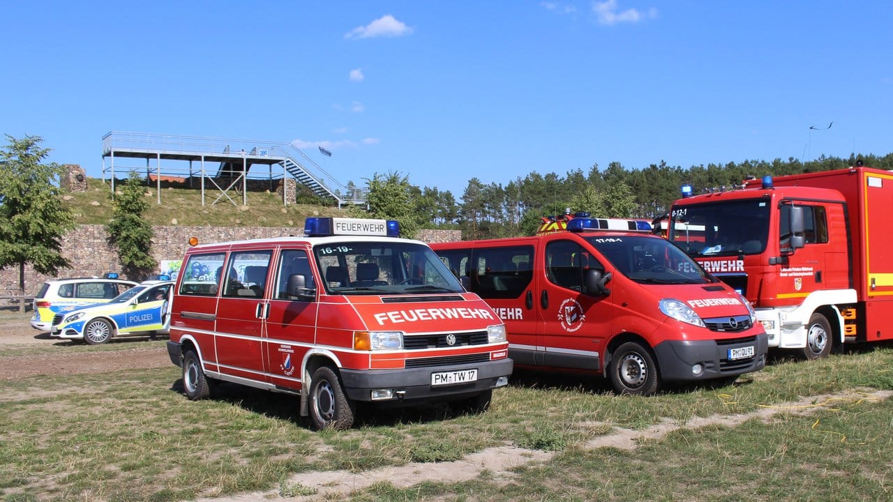 Einsatzwagen von Feuerwehr und Polizei stehen in der Nähe des Brandortes. Einsatzwagen von Feuerwehr und Polizei stehen in der Nähe des Brandortes.
