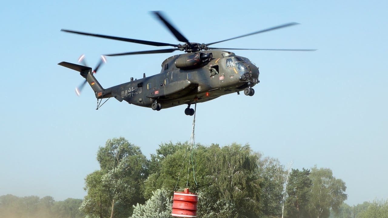 Ein Bundeswehr-Hubschrauber fliegt einen Einsatz bei Potsdam, um die Feuerwehr beim Löschen des Waldbrandes zu unterstützen. Ein Bundeswehr-Hubschrauber fliegt einen Einsatz bei Potsdam, um die Feuerwehr beim Löschen des Waldbrandes zu unterstützen.