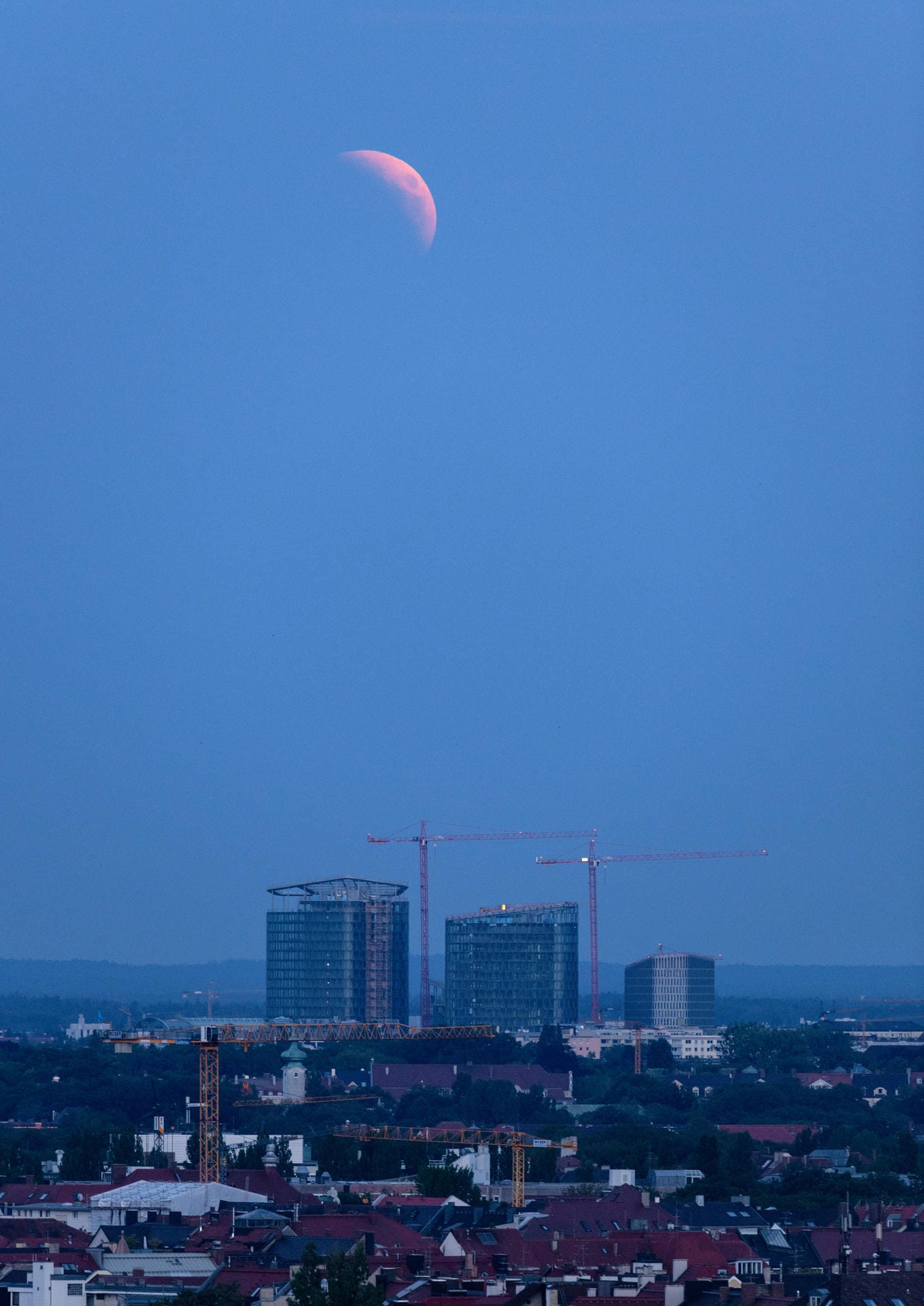 27.07.2018: Der aufgehende Mond ist im Dunst über München zu sehen.