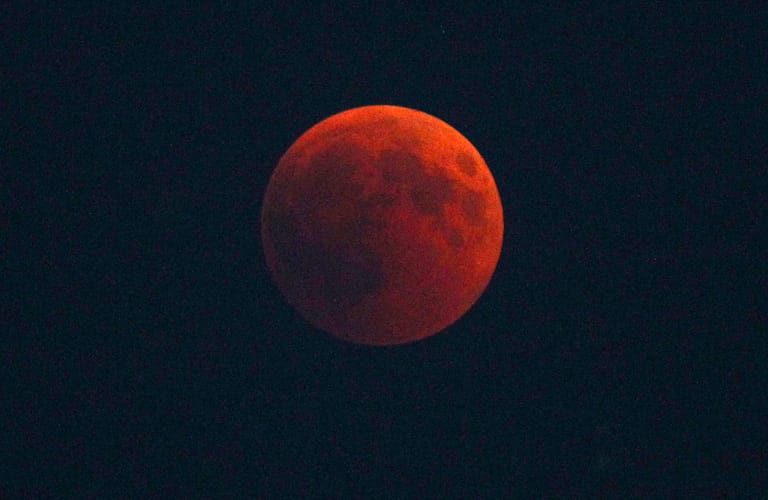 Bayern, Füssen: Der Erdschatten schiebt sich über den rötlichen Vollmond.