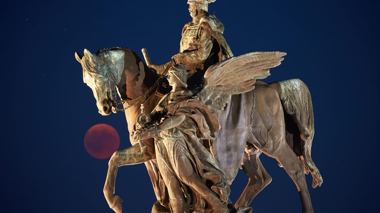 Rheinland-Pfalz, Koblenz: Der Vollmond ist während der Mondfinsternis am Reiterstandbild von Kaiser Wilhelm am Deutschen Eck zu sehen.