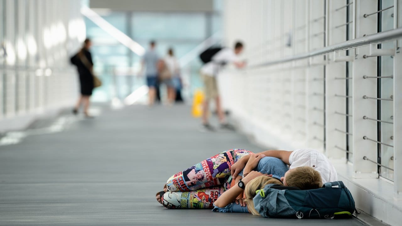 Fluggäste schlafen in einem ruhigen Gang auf dem Flughafen in München. Fluggäste schlafen in einem ruhigen Gang auf dem Flughafen in München.