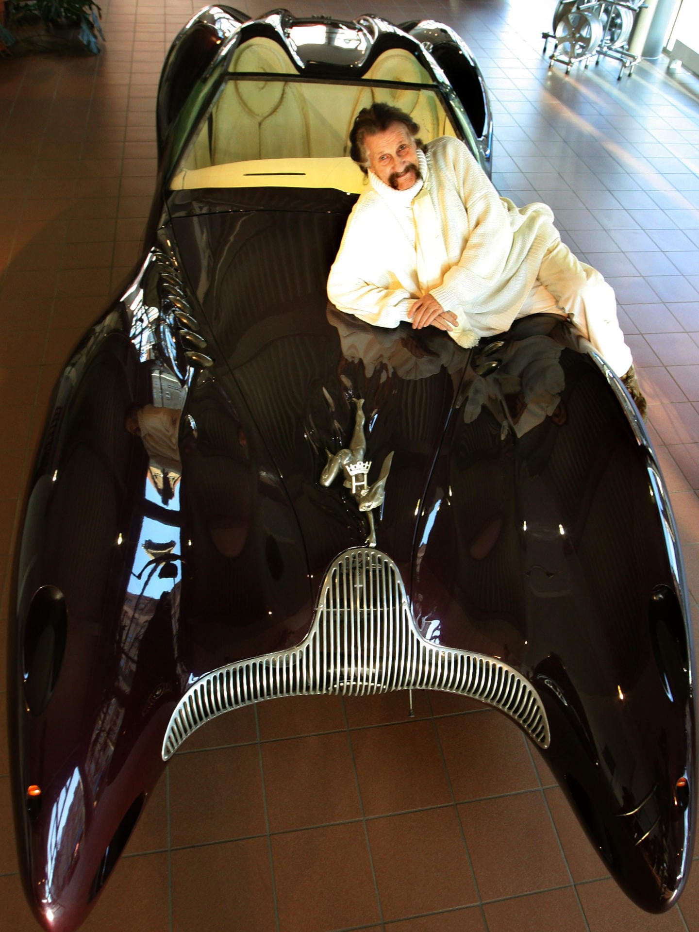 Posieren auf eigenem Design: Luigi Colani liegt auf einem Horch-Colani-Auto. Das Fahrzeug war Teil einer Ausstellung in einem Autohaus in Halle im Jahr 2006.