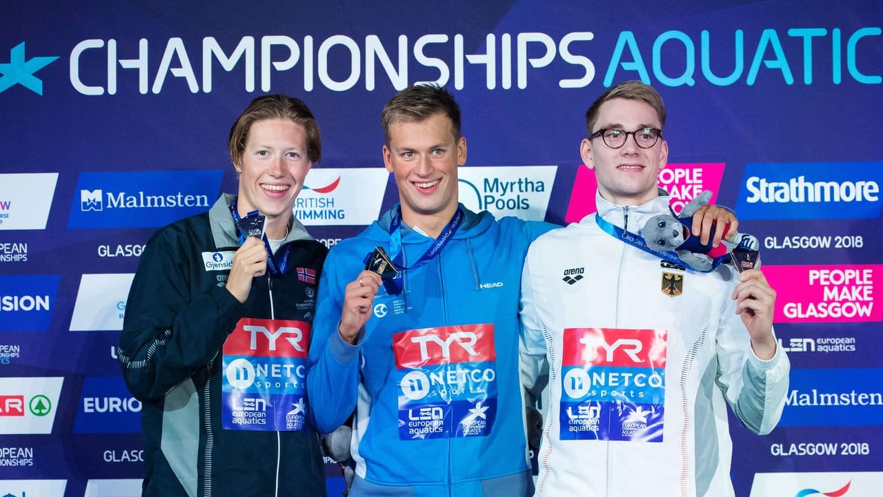 Henning Mühlleitner (r) steht mit seiner Bronze-Medaille neben dem Sieger über 400 Meter Freistil Michailo Romantschuk (M) aus der Ukraine und Henrik Christiansen aus Norwegen.