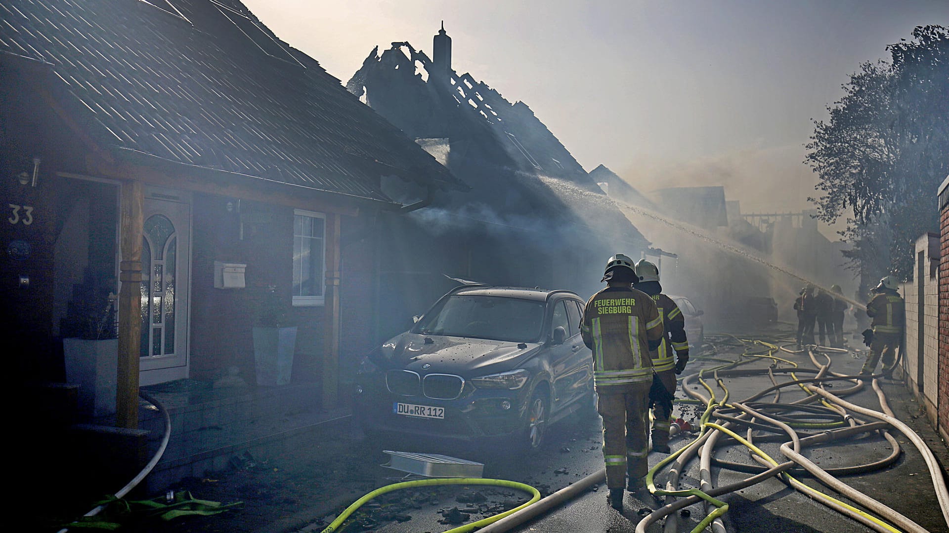 Einen Tag nach dem Großbrand an der ICE-Strecke in Siegburg ist das Ausmaß der Zerstörung deutlich sichtbar. Verkohlte Dachstühle, Garagen in Trümmern, ausgebrannte Autowracks. Wie konnte das passieren? Ein Rückblick auf die Brandkatastrophe.