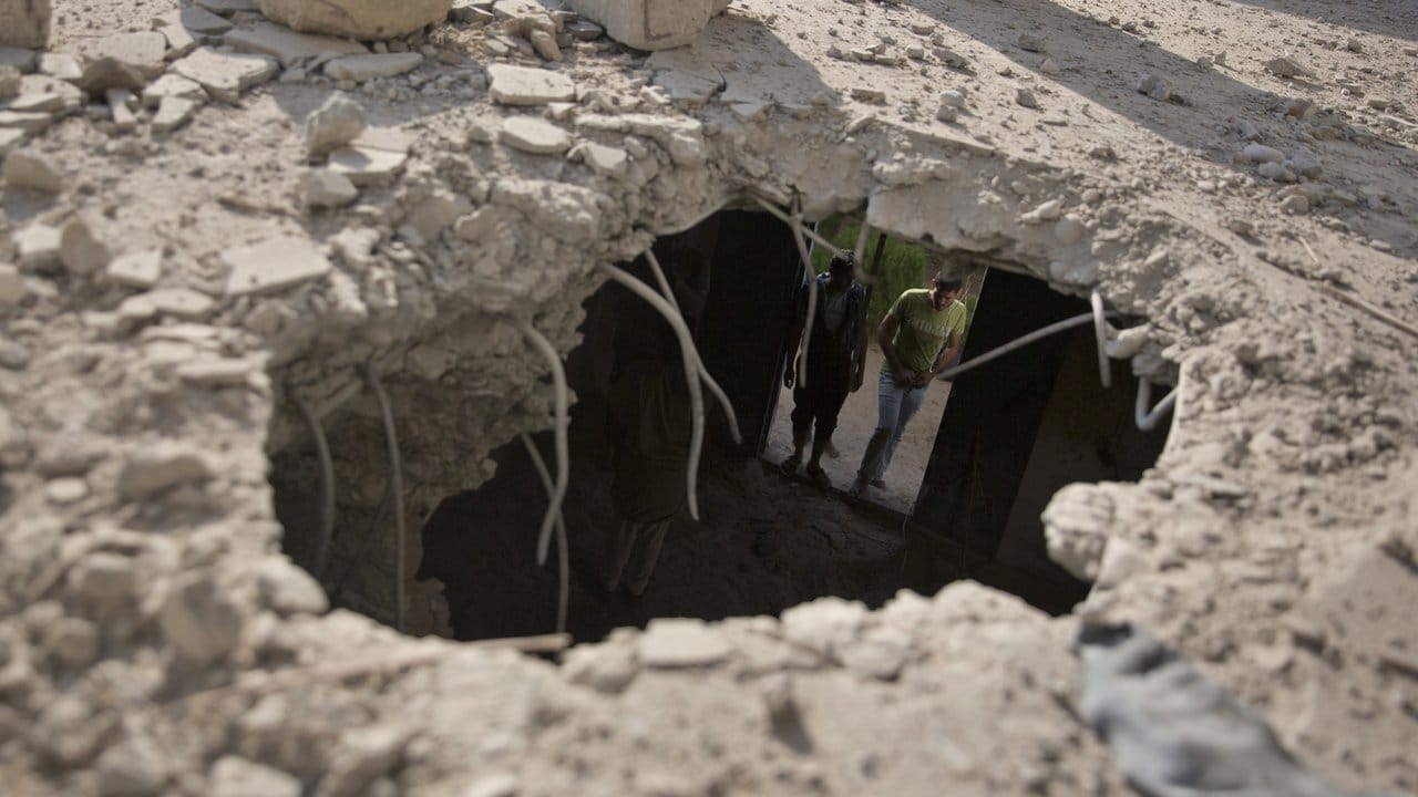 Palästinenser untersuchen ein Haus, das durch einen israelischen Luftangriff beschädigt wurde.