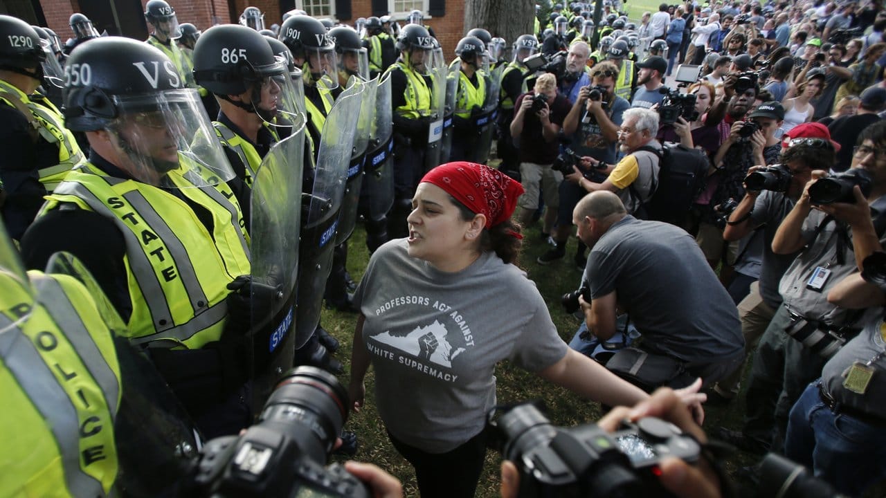 Eine Demonstrantin und Polizisten während einer Demonstration auf dem Campus der Universität von Virginia in Charlottesville. Eine Demonstrantin und Polizisten während einer Demonstration auf dem Campus der Universität von Virginia in Charlottesville.