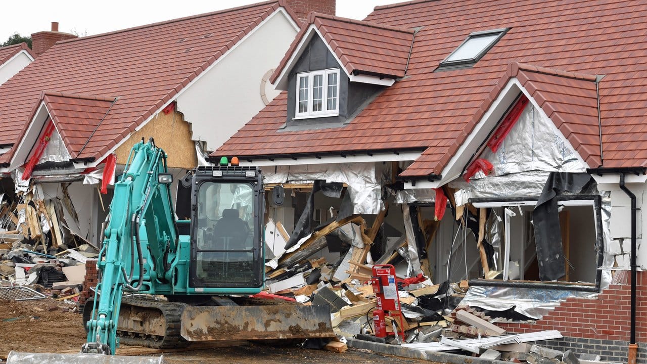 Nach der Amokfahrt: Der Bagger steht vor den beschädigten Gebäuden.