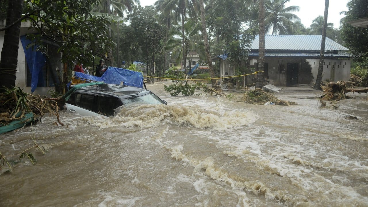 Nur noch das Dach eines Autos ragt auf einer überschwemmten Straße im Bundesstaat Kerala aus den Wassermassen.