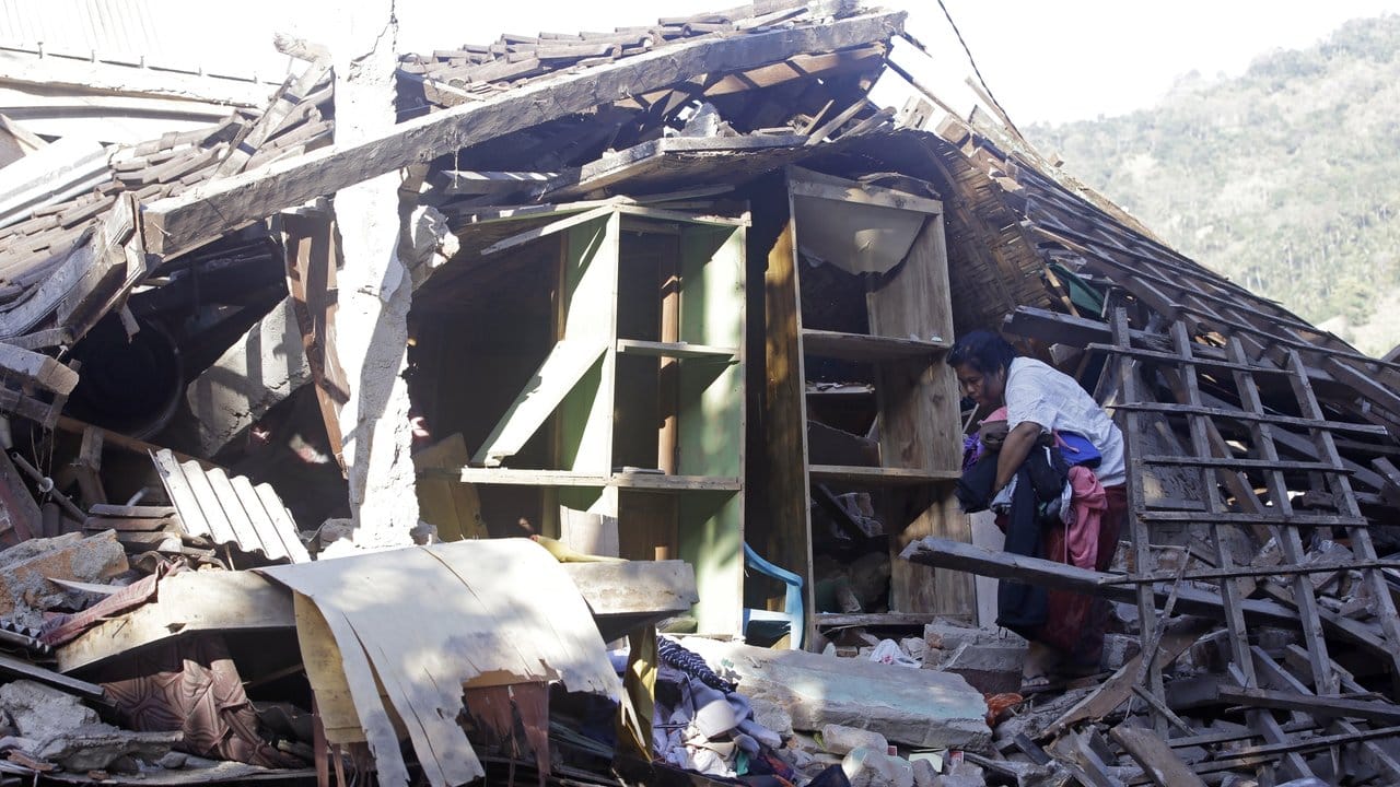 Lombok kommt nicht zur Ruhe: Eine Frau sammelt Habseligkeiten in der Ruine ihres durch ein Erdbeben zerstörten Hauses. Lombok kommt nicht zur Ruhe: Eine Frau sammelt Habseligkeiten in der Ruine ihres durch ein Erdbeben zerstörten Hauses.