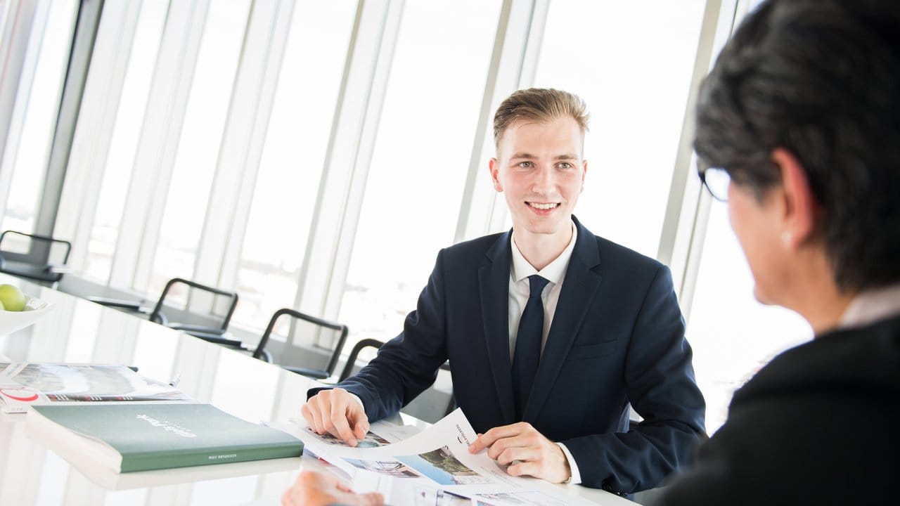 Kundenkontakt ist ein wichtiger Bestandteil des Berufes: Der angehende Immobilienkaufmann David Schmidt berät bei Engel & Völkers in Berlin eine Kundin.