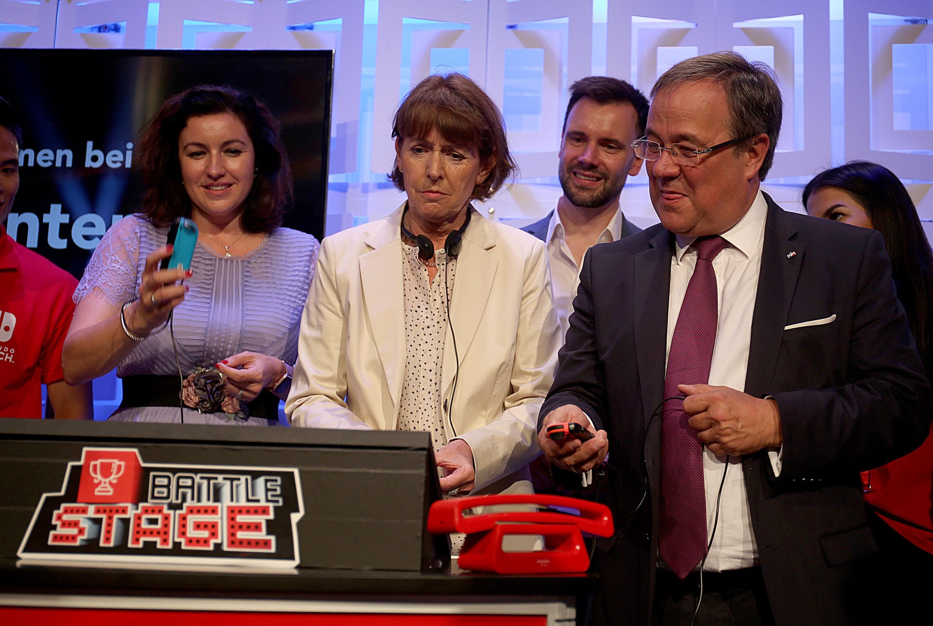 Dorothee Bär, Staatsministerin für Digitalisierung (l, CSU), Henriette Reker, Oberbürgermeisterin von Köln (M) und Armin Laschet (r, CDU), NRW-Ministerpräsident spielen auf dem Stand von Nintendo Battle Stage.