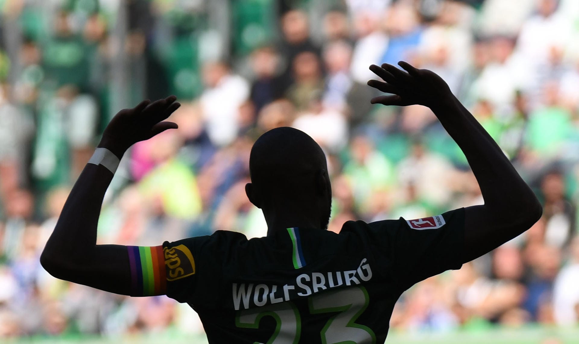 Schattenmann: Wolfsburgs neuer Kapitän Josuha Guilavogui hebt die Arme. Die Kapitänsbinde ist ein Zeichen gegen Homophobie.
