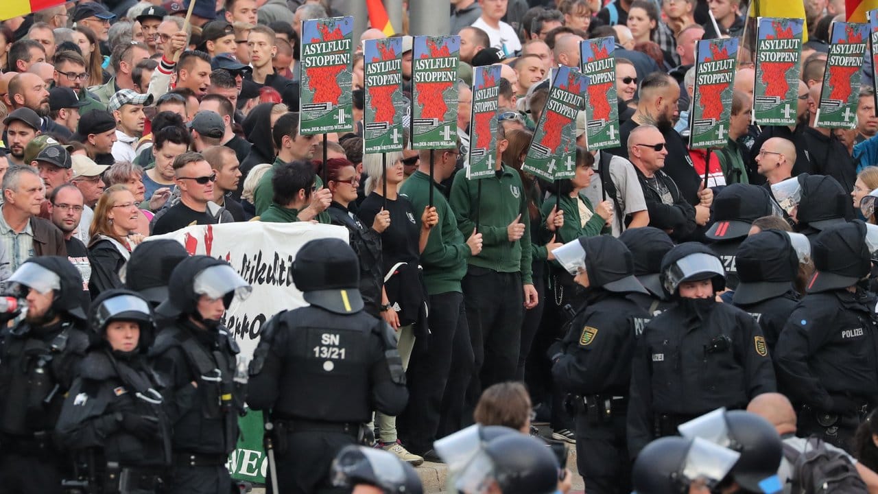 Rechte Demonstranten stehen vor dem Karl-Marx-Monument in Chemnitz. Rechte Demonstranten stehen vor dem Karl-Marx-Monument in Chemnitz.