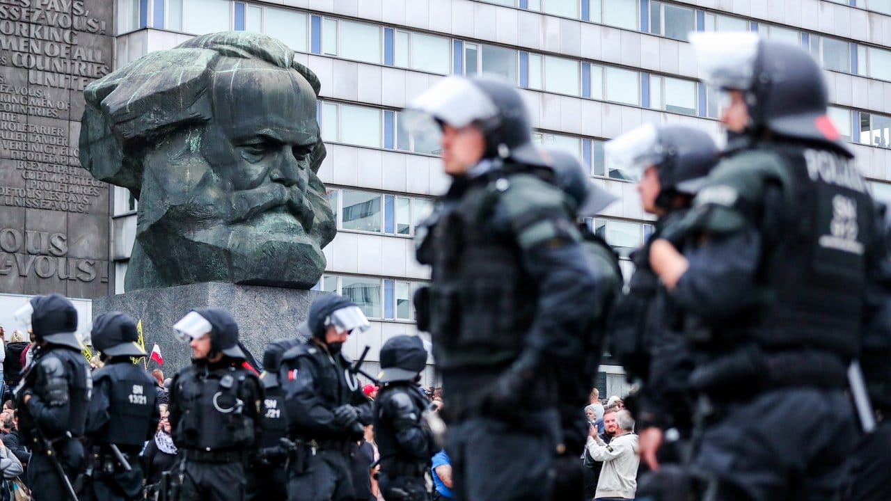 Polizisten haben sich vor dem Karl-Marx-Denkmal postiert.