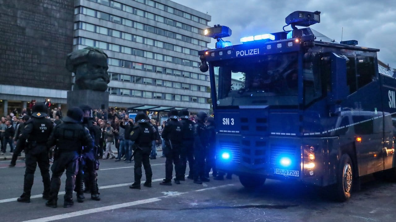 Polizisten sichern mit einem Wasserwerfer eine Demonstration der rechten Szene vor dem Karl-Marx-Denkmal in Chemnitz.