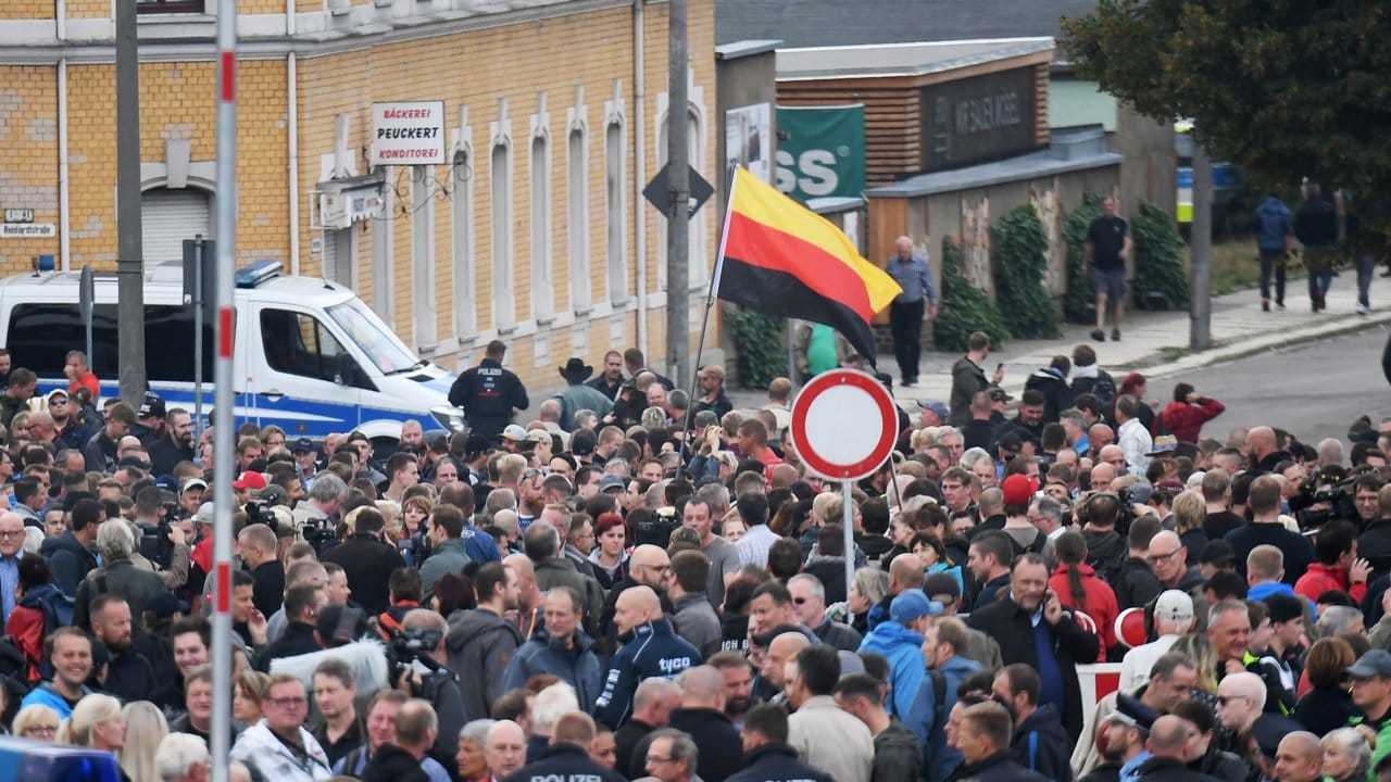Demonstranten mit einer umgedrehten Deutschlandfahne versammeln sich vor dem Stadion vom Chemnitzer FC.