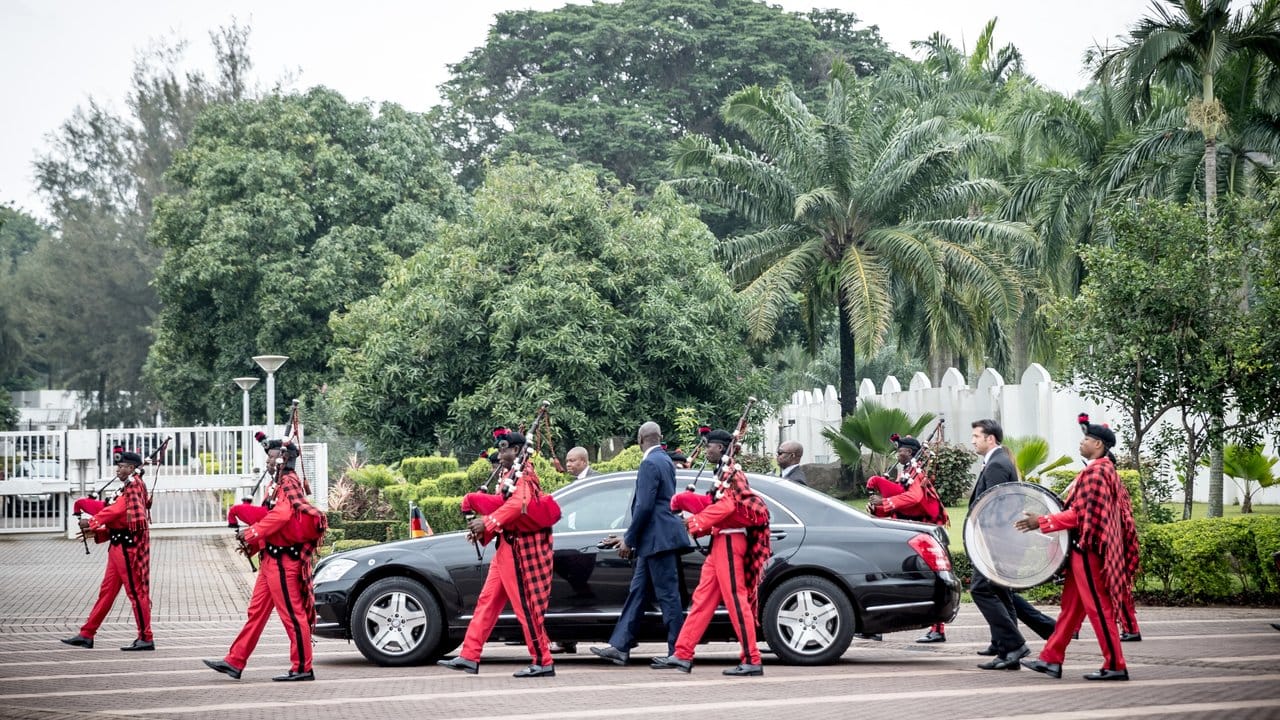 Die Limousine mit Bundeskanzlerin Angela Merkel wird von Dudelsackspielern zum Empfang von Präsident Muhammadu Buhari geleitet.