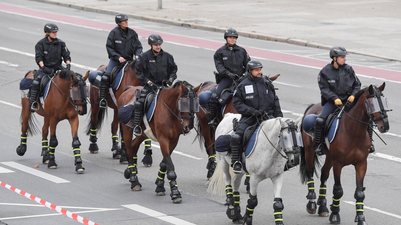 Berittene Polizisten patrouillieren vor dem Karl-Marx-Denkmal. Berittene Polizisten patrouillieren vor dem Karl-Marx-Denkmal.