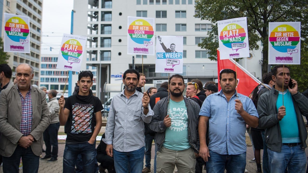 Teilnehmer der Kundgebung des Bündnisses Chemnitz Nazifrei halten Schilder hoch. Teilnehmer der Kundgebung des Bündnisses Chemnitz Nazifrei halten Schilder hoch.