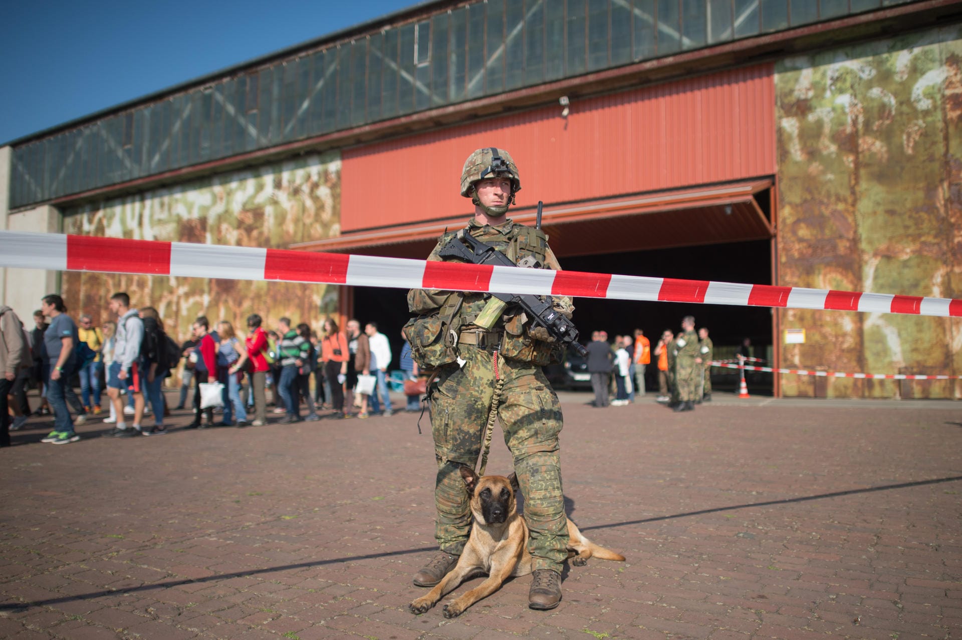 Ein Fallschirmjäger mit Diensthund sichert den Flugplatz.