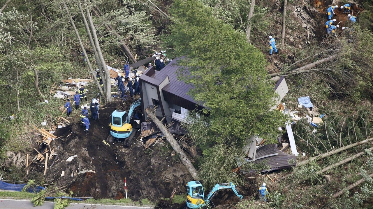 Rettungskräfte sind nach dem Erdbeben an der Stelle eines Erdrutsches in Atsuma im Einsatz.