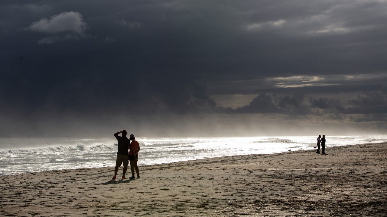 Spaziergänger blicken am Strand von Atlantic Beach dem Hurrikan entgegen.