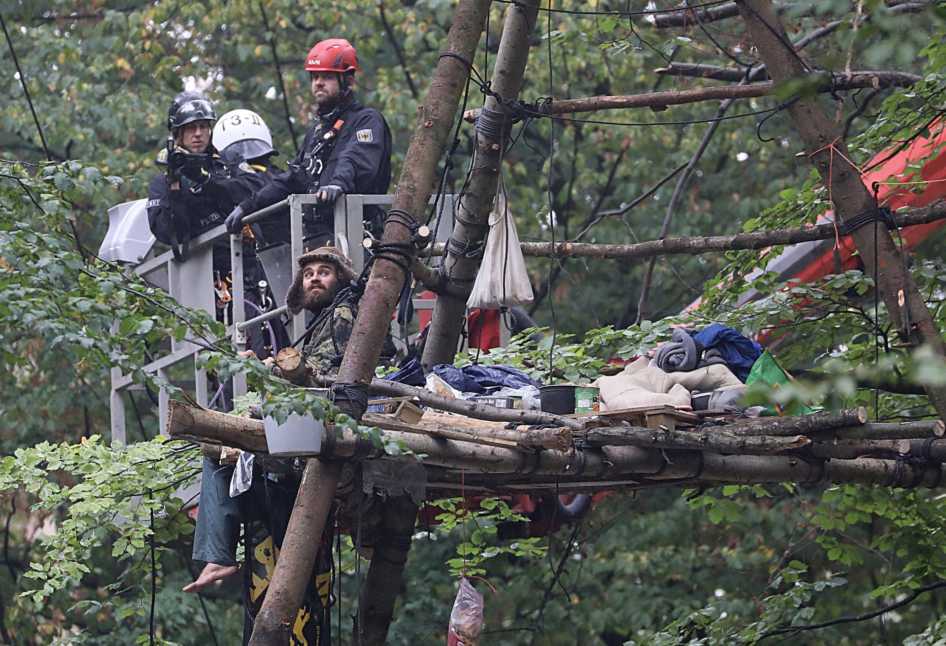 Aufwendige Räumung: Polizisten versuchen mit einem Hubwagen an einen Umweltaktivisten im Baum zu kommen.