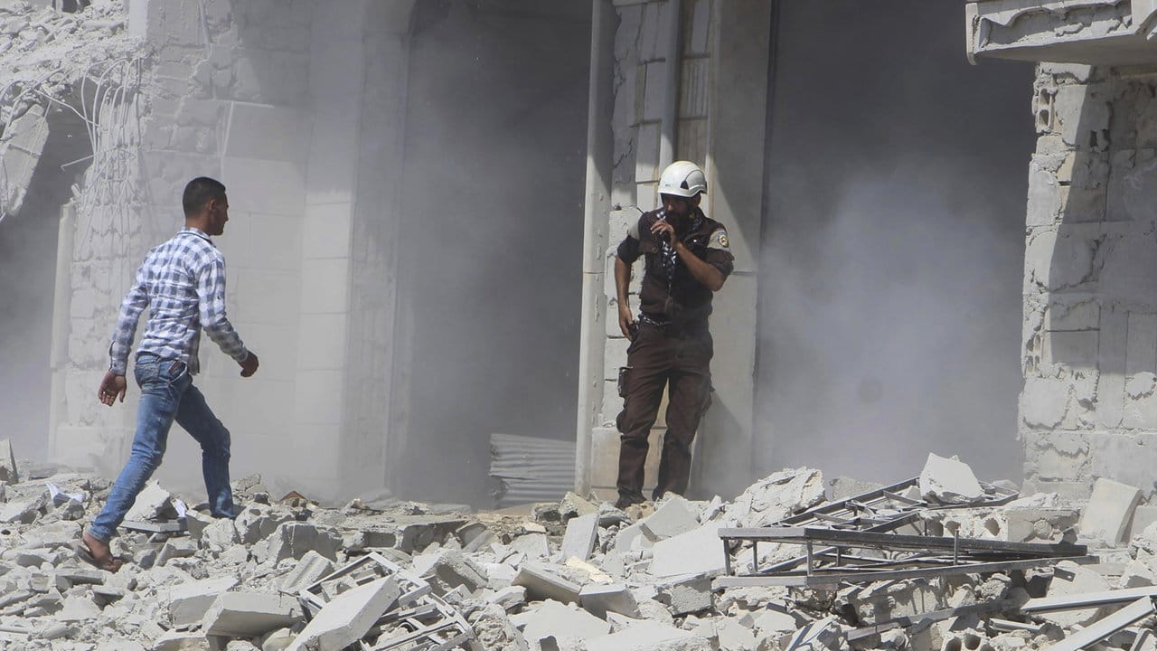 Zivilschutzarbeiter vor einem Gebäude in Hobeit bei Idlib, das durch einen Luftangriff der syrischen Regierung zersört wurde.
