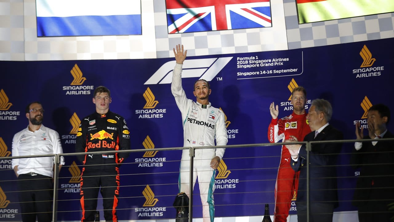 In Singapur feiert Lewis Hamilton (M) zwischen dem Max Verstappen (l) auf Rang zwei und Sebastian Vettel seinen Sieg.