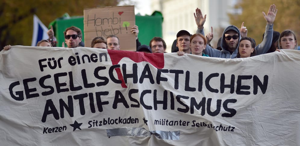 Teilnehmer der Kundgebung «Der extremen Rechten entgegentreten» ziehen mit einem Transparent "Für einen gesellschaftlichen Antifaschismus" durch die Stadt.