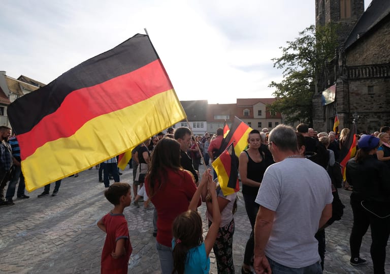 Die Demonstraten des rechtsgerichteten Bündnisses halten Deutschlandfahnen.