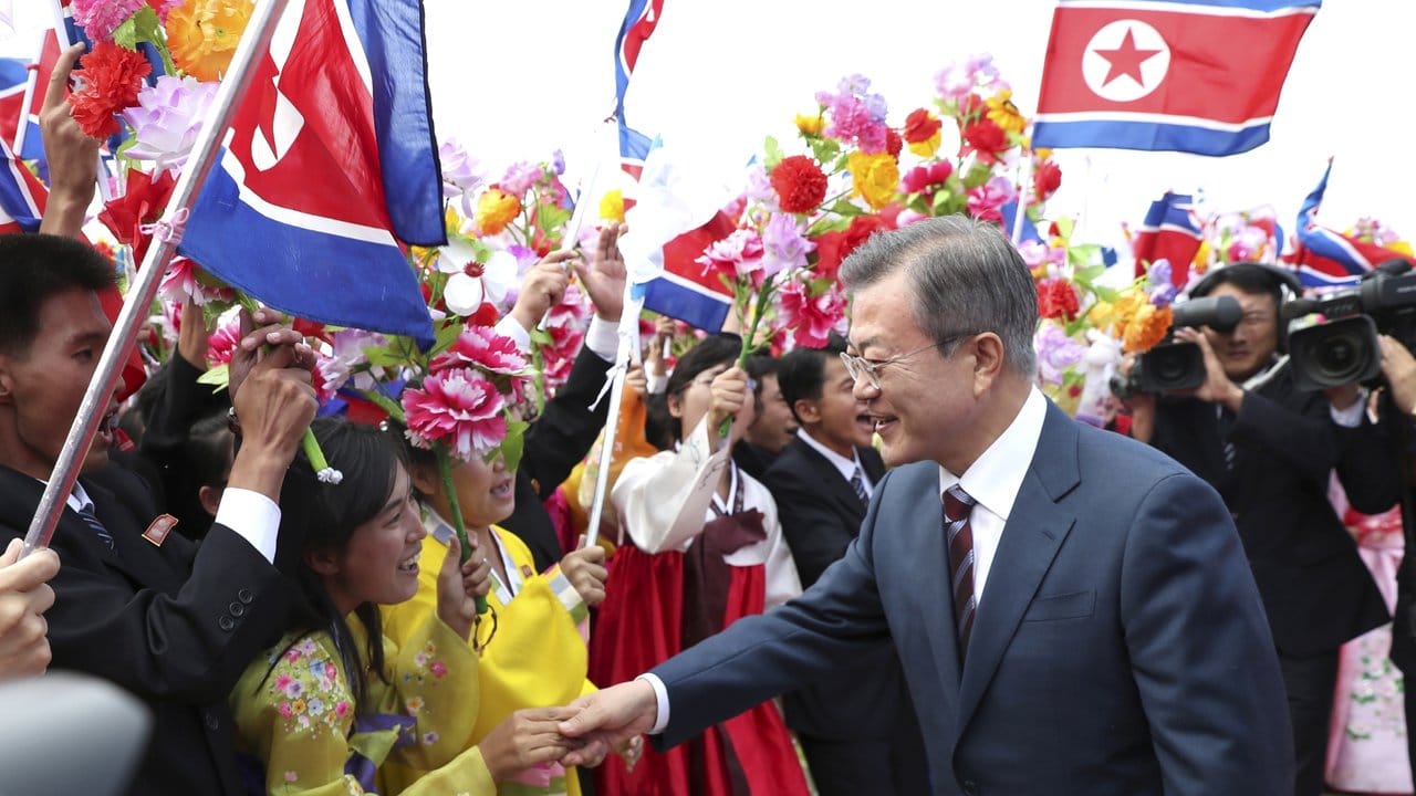 Südkoreas Präsident reicht einem Mädchen die Hand bei einer Willkommensfeier.