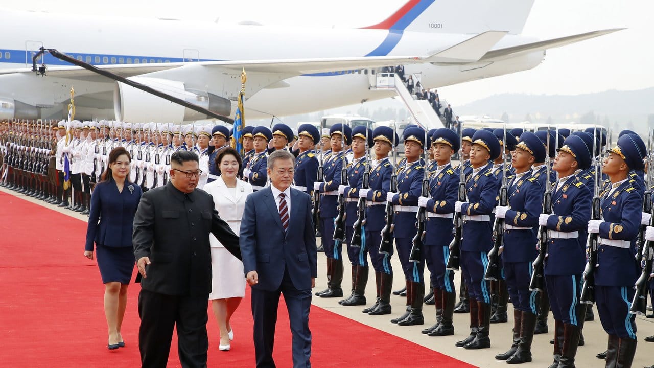 Moon Jae In und seine Ehefrau Kim Jung Sook schreiten in Begleitung von Kim Jong Un und dessen Ehefrau Ri Sol Ju nach ihrer Ankunft auf dem Internationalen Sunan Flughafen die Ehrengarde ab.