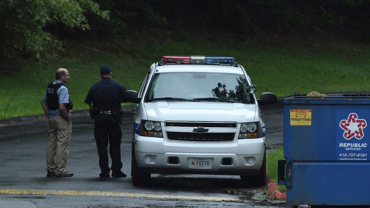 Polizisten in Harford County neben einem Einsatzwagen.