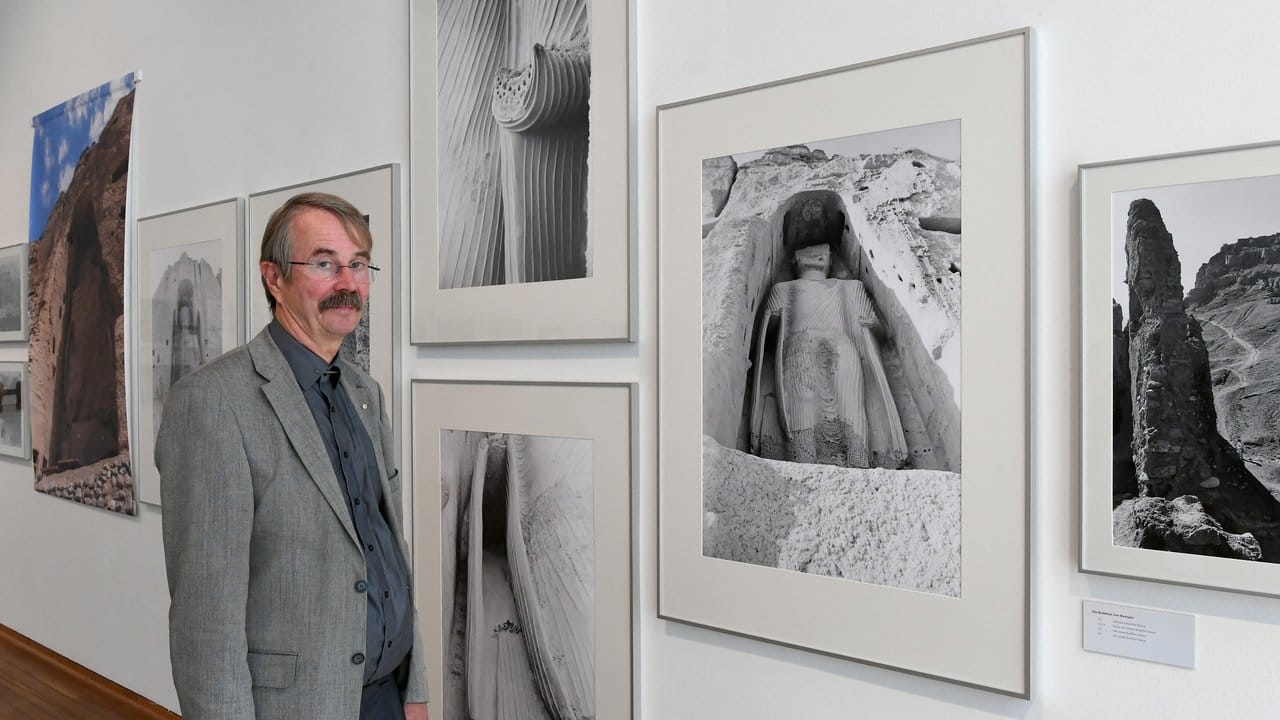 Der Hildesheimer Jochen Blume steht vor seinen 1977 erstellten Fotografien von Buddha-Statuen im afghanischen Bamyan.