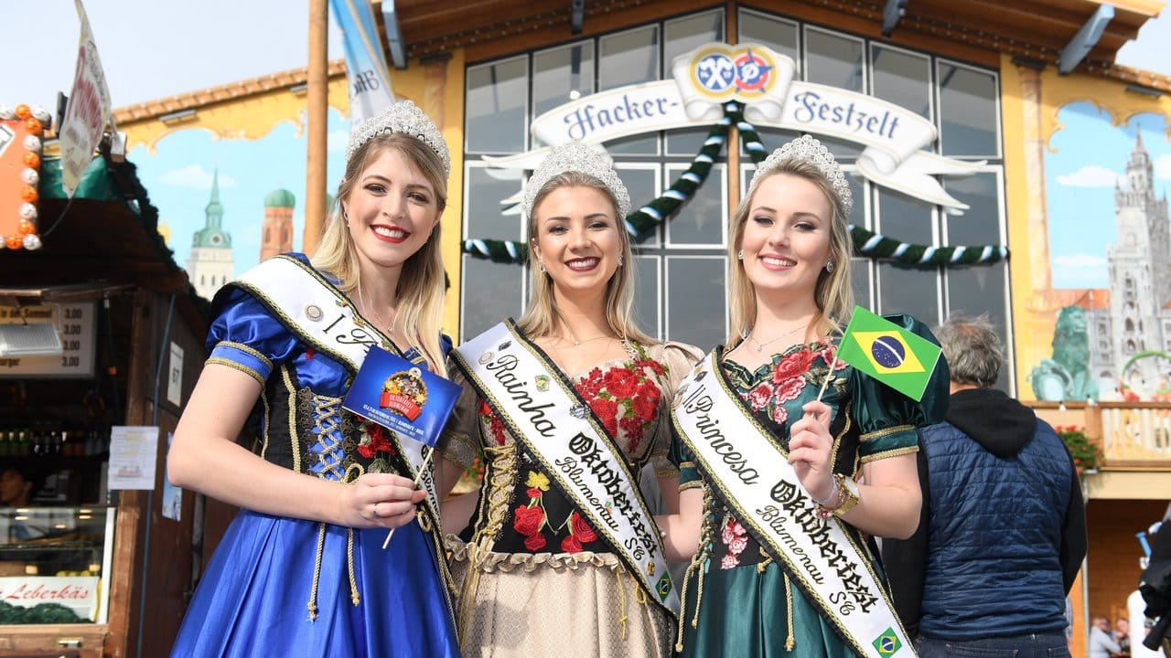 Brasilianische Schönheitsköniginnen stehen vor einem Festzelt.