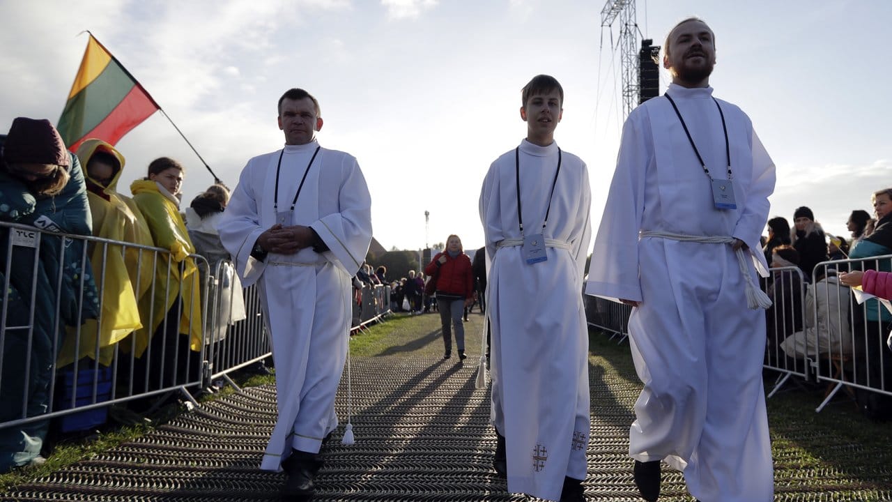Priester nehmen ihre Positionen für die Freiluftmesse ein.