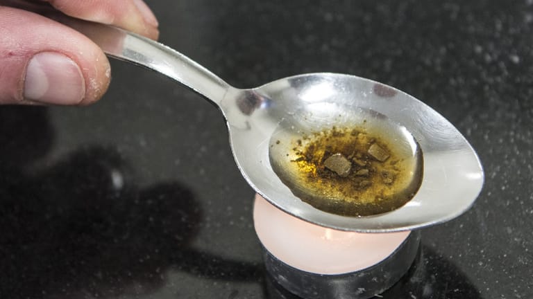 Ein Mann "kocht" auf einem Löffel die Dosis für einen Schuss Heroin: Nach einem Bericht der Weltkommission für Drogenpolitik konsumieren weltweit rund 250 Millionen Menschen illegale Drogen.